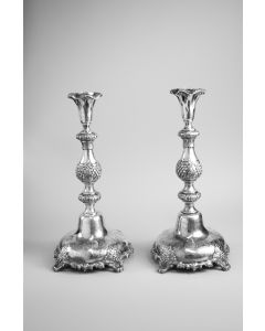 On four cast wreath feet, domed base supports baluster form candlestick with undulating top.  Base engraved with foliate patterns; stem bears embossed grapevine and floral motifs.  Marked on base.  H:  380mm.