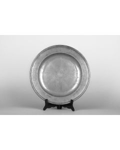 The plate, with raised rim engraved in Hebrew with the Order of the Seder and the name “Hertz Hena”, as well as the date. In center, engraved Star with Paschal lamb at center. Diam: 380 mm.