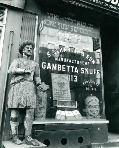 (1898-1991). S. Scharlin & Son Snuff Shop. (Shop-window in English and Yiddish lettering). Gelatin silver print. Signed. Numbered 25/60 in pencil on the mount. Photographer’s New York Portfolio & Parasol Press stamps in ink on reverse.