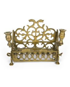With openwork backplate and side-panels; row of eight oil channels fronted by latticework balustrade. Servant light and facing companion-socket serve as Sabbath candle-holders. 8.5 x 8.5 inches.