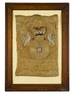 Featuring embroidered crown flanked by metallic embroidered rampant griffins, geometric sphere below. Hebrew text recording name of donor and Hebrew year. 24.5 x 16.5 inches. Unexamined out of frame.