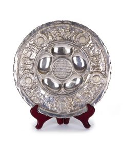 Designed by Ze’ev Raban. Rim bears scenes relating to the Exodus, central roundel contains embossed text of “Mah Nishtanah.” Badge: “Made in Palestine” and hook for hanging on reverse. Diameter: 13 inches.