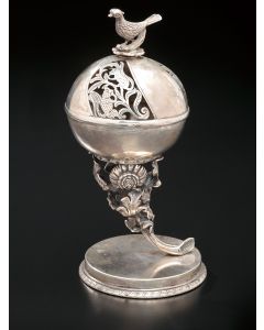 From a flowering stalk rises a chased and pierced globe with bird finial, the whole set on circular base. Marked. Height: 6 inches.
