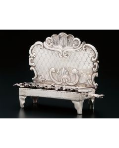 Sofa-style with hinged lid revealing row of eight receptacles with spouts. Rocaille and C-scroll-framed backplate with central shell motif. Leaf projecting from each side (one damaged). Lacks servant light. Repairs on rear. 5 x 6.5 inches.