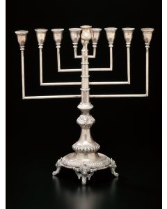 Eight branches emanating from central shaft supporting candle holders; shaft decorated with masques, the whole set on lion-head supports. Later servant light. 17.5 x 15 inches.