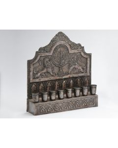 Backplate featuring lions flanking Menorah; fronted by bench supporting eight oil receptacles. 9.5 x 8 inches.