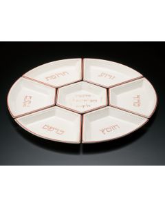 Seven fitted plates painted in red with Hebrew inscriptions referring to the traditional Passover foods; central dish bears inscription from the Hagadah. Diam: 15.5 inches.