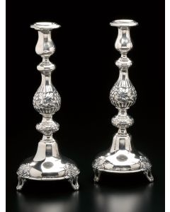 Repoussé baluster shaft with grapevine and floral patterns set on three openwork feet. Candle-cups with Greek-key motif. Marked on base “A. Riedel.” Height: 12.5 inches.