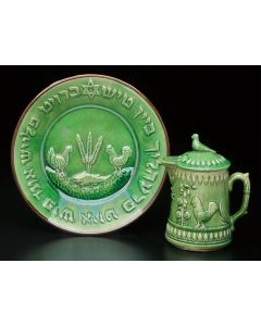 Glazed green plate featuring imagery of chickens, fish and wheat stalks surrounded by the Yiddish text: “Bread, meat and fish bring pleasure to the meal” (paraphrase of Nechemiah 8:10). Plate 10.5 inches (diam.) Pitcher (with lid) 8 inches (height).