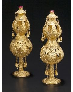 Two tiered bulbous form, each tier hung with pendant bells (one lacking), decorated throughout with floral designs; surmounted by faceted red gemstone. Height: 6 inches.