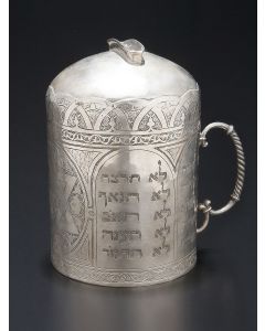 Tankard-shaped with coin slot atop and wooden coin release at base. Chased and engraved throughout, bearing Hebrew Decalogue titles and ‘Zion,’ large Star-of-David and arabesque motif of foliate scrollwork. Height: 6 inches; Diameter: 4 inches.