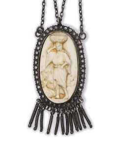 Oval ivory cameo depicting biblical-style woman carrying a basket on her head. Set in mounting with decorative, pendant ornaments. Tab insert closure. Cameo: 1.25 x .75 inches.