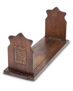 Rectangular base with two hinged bookends, each featuring inlaid marquetry; one bearing image of an elderly Jew studying the Torah, the second bears the Hebrew dictum: “And you shall meditate therein day and night” (Joshua 1:8). 12.5 x 4 x 5.5.