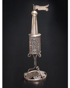 Cylindrical spice chamber comprised of filigree design with arched, hinged door; conical steeple and pennant finial set on knop. The whole set on three wire legs and round filigree base enclosing filigree floral element. Height: 7.25 inches.
