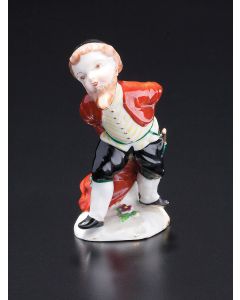 A realistically modeled young, bearded Jewish man with frock-coat, yarmulke, dagger and spats standing on floral base. Marked with underglaze blue ‘N’ beneath crown. Height: 3.75 inches.
