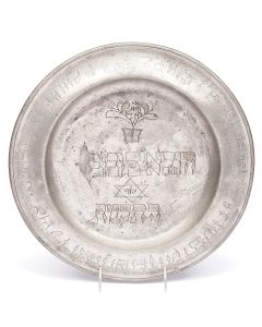Round plate with raised rim bearing Hebrew inscription. A gift from the communal boards of the town of Marshiz, to the Bridegroom Leib Frieschel. Diameter: 13.75 inches.
