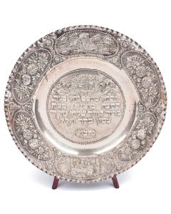 Chased with Order of the Seder in Hebrew at center; floral and fruit designs along wide rim interspersed with vignettes of the Exodus and a Passover Seder. Marked. Diam: 19.25 inches.
