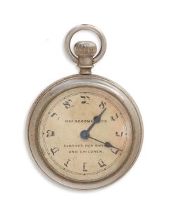 Silver-toned case with Hebrew dial-face featuring ad: “Max Goodman & Co. Clothes for Boys and Children” [sic]. Diam: 2 inches.