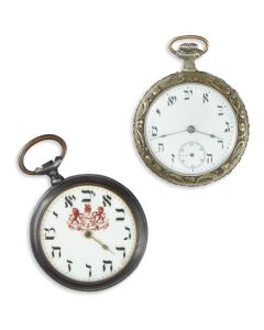 Silver-toned cases each with Hebrew dial-face. One featuring lion and unicorn crest and the Hebrew words: “May God bless and protect you.” Second with Moses and the Decalogue on verso. Diam: 2 inches (5 cm).