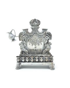 Crafted by M. Charlop. Rectangular base with eight oil holders. Backplate chased in royal design featuring Menorah at center. The whole set on four decorative feet. Signed. 9.5 x 7 inches (24 x 18 cm).