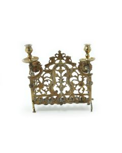Backplate decorated with lions, flowers with urn at center. Fitted with row of eight oil receptacles with spouts; twin candle-holders at sides. Set on four leg supports. 10.5 x 9 inches (26.5 x 23 cm).