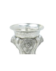 Of elaborate rococo design, rim engraved with lengthy Hebrew inscription from the “Bachurei Eidah” to: <<HaGaon Binyamin Tzvi Auerbach, Chief Rabbi of Halberstadt.>> Shabbos Parshath Emor, 1863. Height: 10 inches (26 cm).