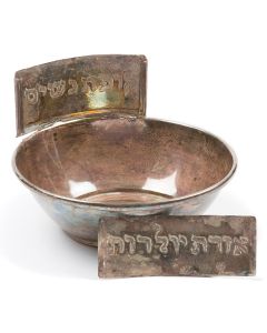 Tea bowl with soldered finger-hook and rectangular collar slot. Accompanied by two silver-plate plaques engraved “Ladies’ Fund” and “Aid for New Mothers.” Diameter: 5 inches.