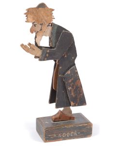 Painted wooden figure of a moveable praying Jew balanced on a central shaft, mounted on rectangular wooden base with city name: “Kodeń.” 12.75 inches (including stand). Some paint loss.