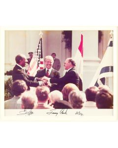Photograph of the Camp David Accords signing ceremony, the White House. Signed along lower margin by Presidents Jimmy Carter, Anwar Sadat and Prime Minister Menachem Begin.