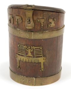 Cask-like box featuring applied Hebrew letters of “Charity” and the Temple Menorah and Table. Hinged, angled lid with coin slot and lock-latch. Additional iron riveted hardware. Height: 7.5 inches.