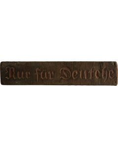 Rectangular wooden sign bearing carved German phrase: Nur für Deutche [“For Germans Only.”]
