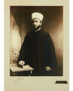 (Grand Mufti of Jerusalem, 1897-1974). Three-quarter length, silver-print photograph by C. Raad of Jerusalem, with signature below.