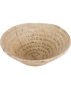 An ancient Jewish-Babylonian incantation bowl with an outward spiraling text inscription around an interior cross in eight lines with four Biblical quotations including the Shema. Diam: 7 inches (18 cm).