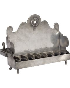 Bench-form, scalloped backplate with suspension-hole fronted by removable row of eight oil receptacles; scalloped sides with removable servant light; the whole set on four supports. Marked. 6 x 8 inches (15.2 x 20.3 cm).