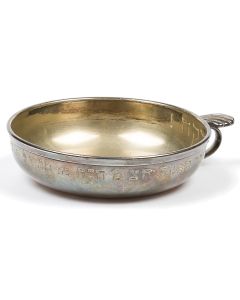 Shallow bowl with shell-topped finger hook bearing engraved Hebrew inscription: “A memorial to the refined Lady, Chana daughter of Mattel Goldfarb, from her son, [5]697 (1937).” Additional Hebrew inscription along interior: “Charity.” Diameter: 5 inches.