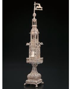 Four graduating rectangular tiers with filigree ball and flag finial in the form of a deer. Matching filigree square base, set on ball and claw feet. Single bell in belfry section and circled at base by four pennants. Hinged door. Height: 13.5 inches.