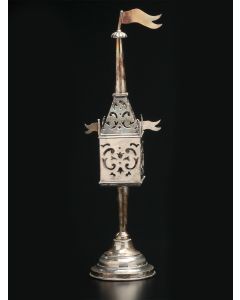 Pierced rectangular container with corner flags (lacking one), conical steeple and flag finial. Hinged door. The whole set on circular base. Marked. Height: 10.5 inches.