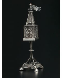 Rectangular container with steeple set above with double flower-head surmounted by pennant. Set on four wire supports. Hinged door. Marked. Height: 7.5 inches.