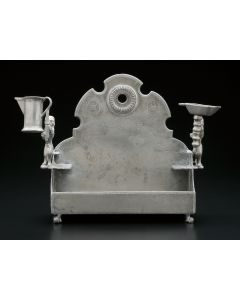 Bench-form, backplate with suspension-hole fronted by row of eight oil receptacles; sides fitted with rampant lions bearing removable pitcher and servant light; set on four ball-and-claw supports. Marked. 8 x 9 inches.