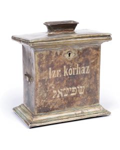 Rectangular form, with coin-slot set atop hinged lid, engraved in Hungarian “Jewish Hospital” and in Yiddish “Hospital.” Sides fitted with strap brackets; and stepped base. 9.75 x 8.5 x 5.5 inches.